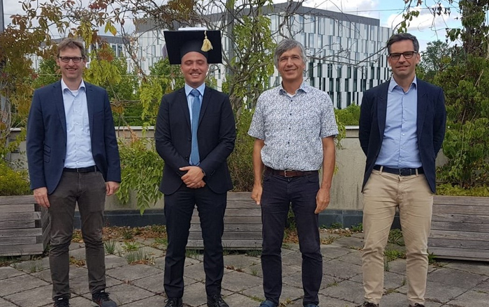 Prof. Bernhard Wolfrum (TUM), Julian Angermeier, Prof. Werner Hemmert (TUM) und Prof. Stefan Zirn (HSO, von links) stehen vor einem Gebäude der TU München 